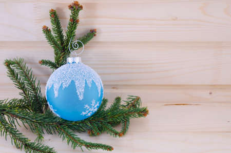 Blue Christmas ornament on a wooden table, decorated with a fir branchの写真素材