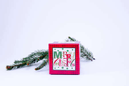 Red present box and a fir branch on whiteの写真素材