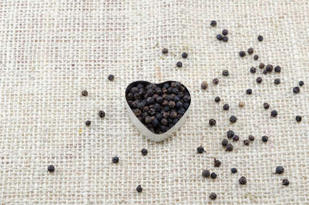 Pepper in a heart shaped box on a tableclothの写真素材