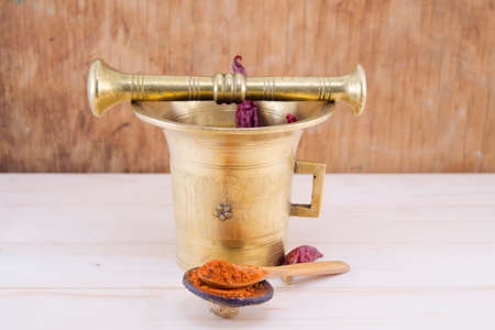 Vintage pepper mortar on a wooden table with grounded pepperの写真素材