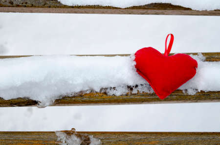 Heart on a snow covered bench outdoorsの写真素材