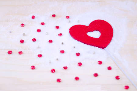 Red heart and red star ornaments and pearls on white powderの写真素材