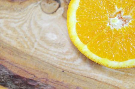One half of an orange close up on a plankの写真素材