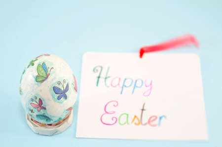 Hand painted decoupage Easter egg with butterfly pattern, and a Happy Easter cardの写真素材