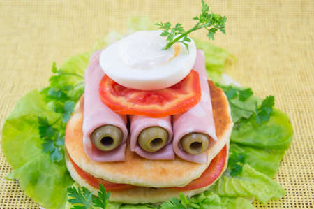 Homemade ham sandwich with olives, tomato and cooked eggs
