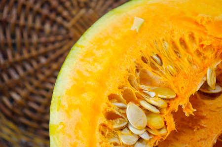 Ripe halved pumpkin against a wooden surface