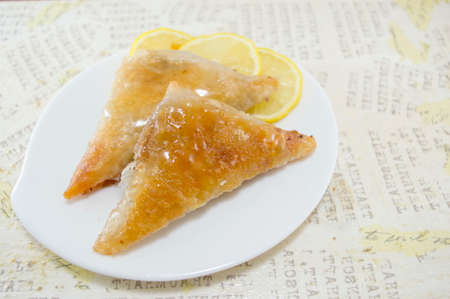 Triangle shaped Turkish Baklava on a plate with decoupage backgroundの写真素材