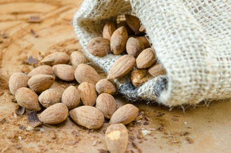 Baked salty almonds falling out of a vintage bagの写真素材