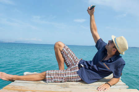 Man taking a selfie on the beachの写真素材