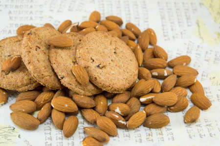 Decoupage table covered with raw almonds and integral cookiesの写真素材
