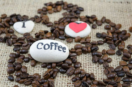 Roasted coffee beans with a "I love coffe" message on a vintage tableclothの写真素材