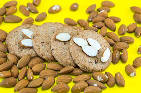 Table covered with raw almonds and integral cookiesの写真素材