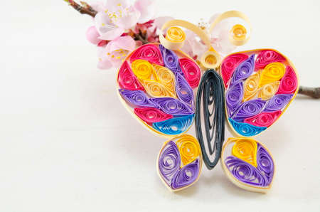 Handmade paper butterfly and a cherry blossom on whiteの写真素材