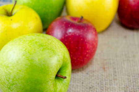 Yellow red and green apples arranged togetherの写真素材