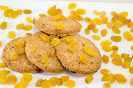 Integral cookies and yellow raisins on whiteの写真素材