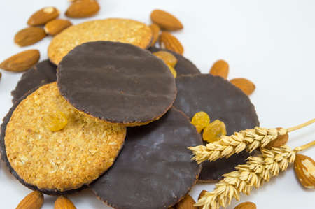 Integral chocolate cookies with almonds and wheat on whiteの写真素材