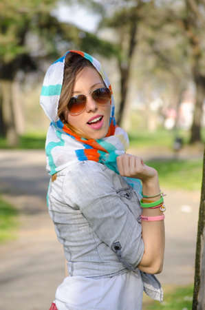 Girl enjoying spring wearing a colorful bandana and sunglassesの写真素材