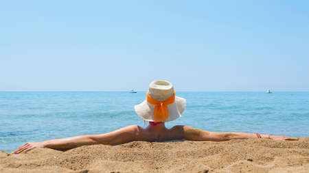 Young girl looking at sea while sitting on the beach