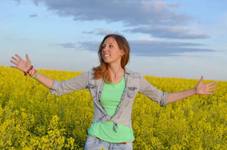 Beautiful girl posing in a field of yellow flowersの写真素材