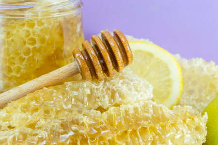 Honeycomb dipper and lemon close up on a handmade decoupage table