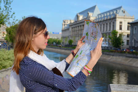 Young girl reading a map close to a river in Bucharestの写真素材
