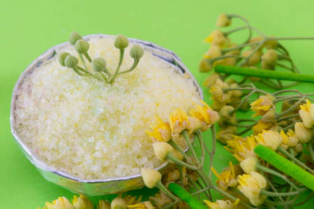 Gren bath salt decorated with linden flowers on a green backgoundの写真素材