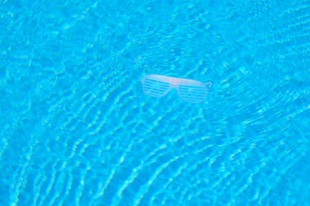 White rave dance shutter glasses floating in the swimming poolの写真素材