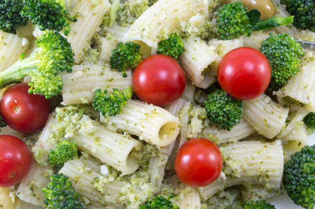 Pasta with broccoli and whole cherry tomatoes served close-upの写真素材