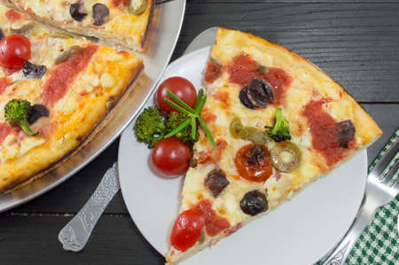 Vegetarian pizza slice served with cherry tomato and broccoli. Vegetarian meal.の写真素材