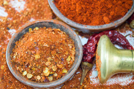 Different form of paprika. Dried grounded, chopped and whole peppers in natural wooden bowlsの写真素材
