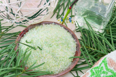 Gren bath salt in a bowl  with rosemary on next to parfume bottleの写真素材