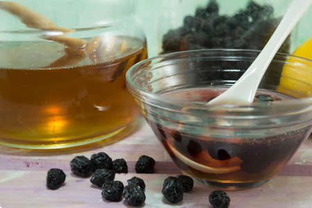 Aronia and honey in  a glass dish next to a jar with honey. Fruit and honeyの写真素材