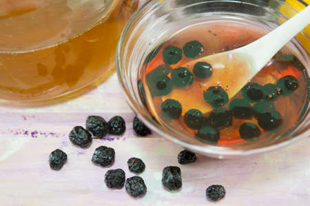 Aronia and honey in  a glass dish next to a jar with honey. Fruit and honeyの写真素材
