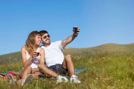 Couple of hikers making selfie with a retro camera  while on pause while hiking