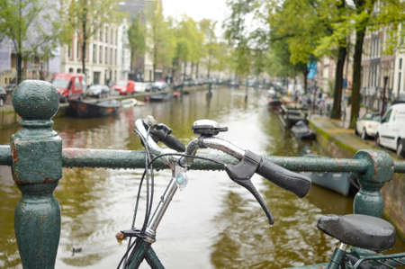 Bicycle parked on a bridge in Amsterdam on a rainy dayの写真素材