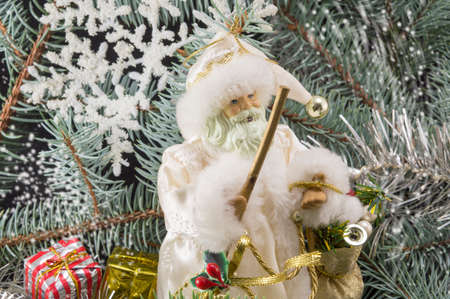 Toy Santa among fir trees, presents and snowflakes. Christmas abstract