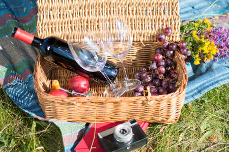 Picnic equipment in a wicker basket on a blak\nket outdoorsの写真素材