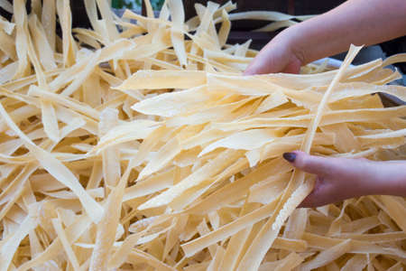 Homemade pasta in woman hands. Pasta production processの写真素材