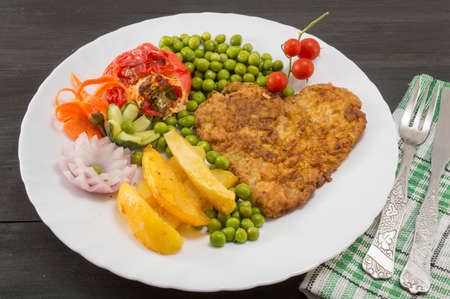 Heart shaped steak with potatoes, cherry tomatoes and green beans on a plateの写真素材
