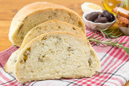 Sliced olive bread with seeds and olives served on the table