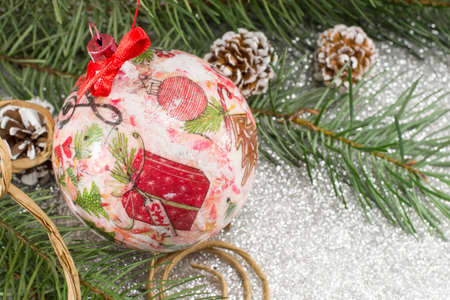 Decoupage decorated Christmas ornament and fir tree on shiny backgroundの写真素材