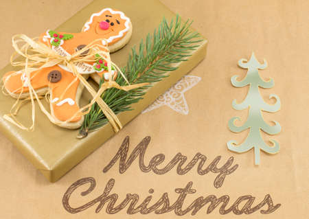 Merry Christmas card with Christmas present with gingerbread and fir treeの写真素材