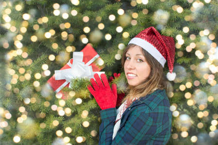 Beautiful girl with Santa Claus hat taking her Christmas present