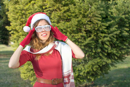 Portrait of a beautiful Santa Claus girl with party sunglassesの写真素材