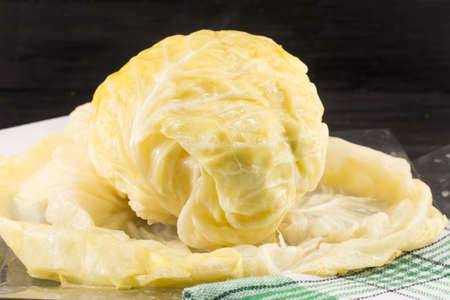 Head of sauerkraut and rolled cabbage leaves on a table