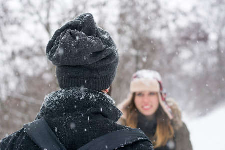 boy and girl looking at each other while it is snowingの写真素材