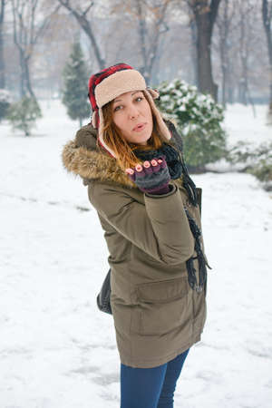 girl blowing a kiss in winter wearing a lumberjack hat