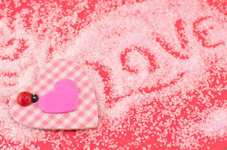 Pink plaid heart and the word love written in bath saltの写真素材
