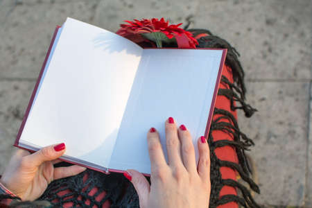 Brunette girl finished reading a book outdoors