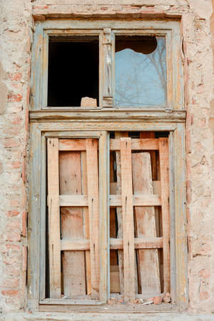 old broken window boarded up